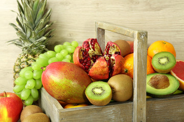 Assortment of exotic fruits in box on wooden background