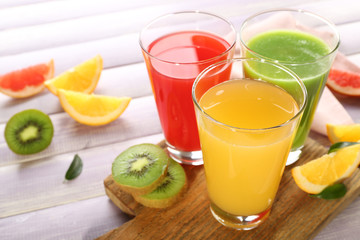 Fresh juices with fruits on wooden table