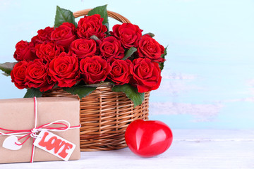 Bouquet of red roses in basket with present box