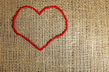 Linen canvas with red heart embroidered on it, close-up