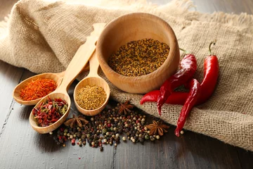 Poster Different kinds of spices on wooden background © Africa Studio