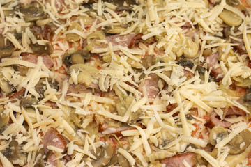 Unbaked pizza with bacon and mushrooms, close-up