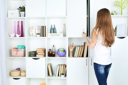 Woman looking for something in closet, in room with modern