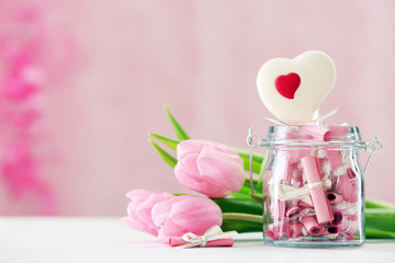 Beautiful pink tulips with jar of papers