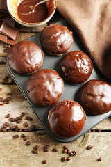 Tasty homemade chocolate muffins on wooden table