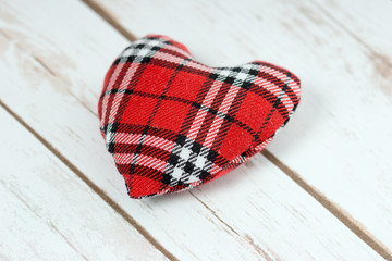 kariertes Herz auf einem Holzbrett