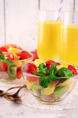 Fruit salad with mint and orange juice in glassware
