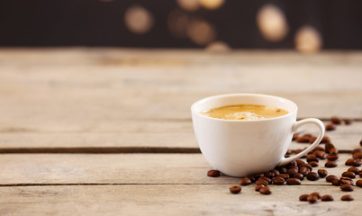 Cup of coffee on table on brown background