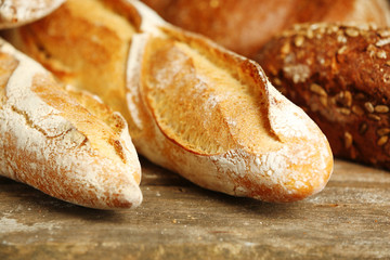 Different fresh bread on old wooden table