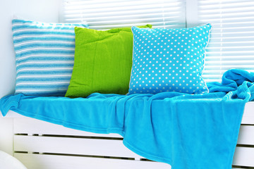 Colorful pillows on windowsill