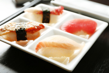 Sushi on plate on wooden table background