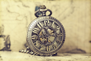 Old pocket watch over vintage map