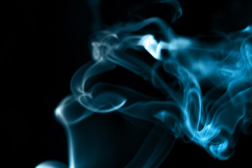 The smoke from the incense on a black background