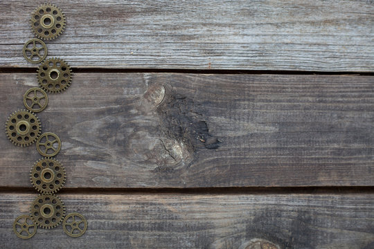row of gears on a wooden background