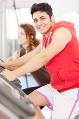 Fototapeta na wymiar Young adult man looking at the camera while doing workout on the