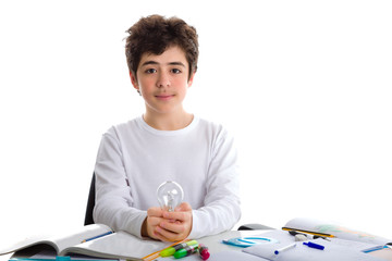 Fototapeta na wymiar Caucasian boy holds a lightbulb while doing homework