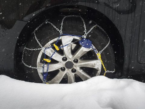 snow chain on car tyre in snow