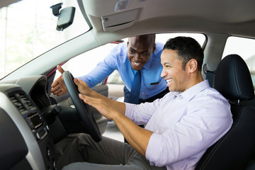 african salesman explaining car features to customer