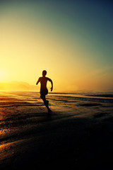 Fototapeta na wymiar young woman running on sunrise beach 