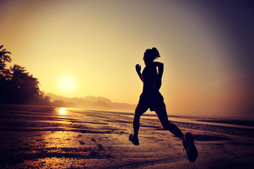 Obraz na płótnie Canvas young woman running on sunrise beach 