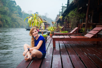happy young woman at beach house on the River Kwai in Thailand
