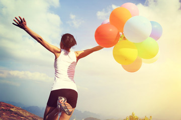  young asian woman mountain peak  with colored balloons 