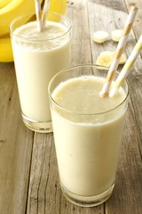 Healthy banana smoothies in glasses on wood table
