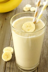 Healthy banana smoothie in a glass on wood table