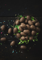 Small chocolate Easter eggs on wooden background