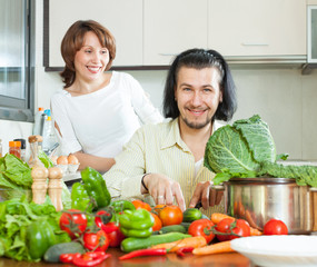 Young couple preparing vegetable salad