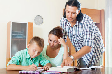 schoolboy and parents doing homework together