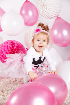 Happy baby girl playing with balloons