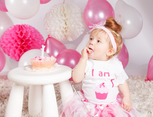 Obraz na płótnie Canvas Cute baby eating the birthday cake