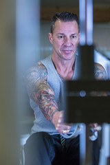 young man making cable row - workout routine .