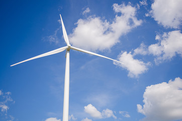 wind turbine against cloudy blue sky background
