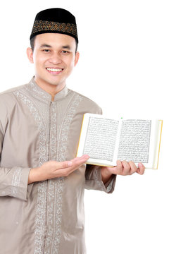 young muslim man showing a Quran