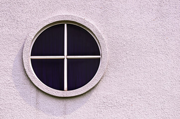 an oval window on cement wall