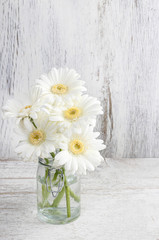 Bouquet of white gerbera flowers on wood