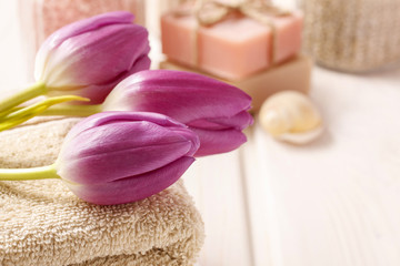 Obraz na płótnie Canvas Spa set: bouquet of tulips on a towel, sea salts and bar of soap