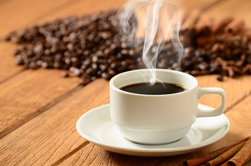 Coffee cup with smoke and coffee beans around
