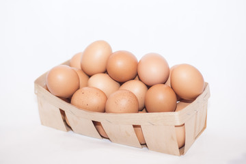 brown eggs in a wooden box, on a white background