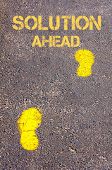 Yellow footsteps on sidewalk towards Solution Ahead message