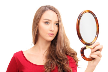 Gorgeous woman looking herself in a mirror