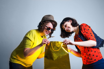 two women open bag with surprise