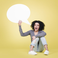 Happy girl holding a empty speech bubble.