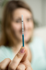 portrait of happy woman showing positive pregnancy test