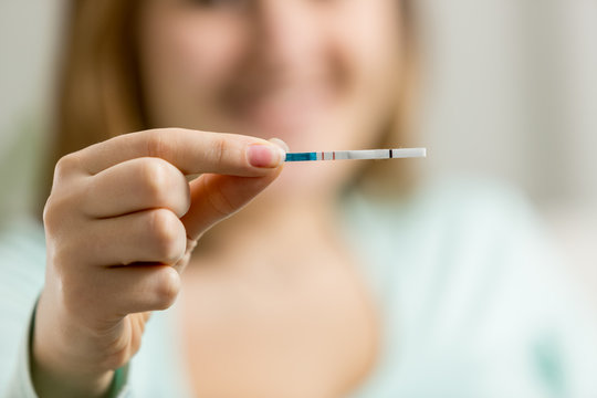 woman holding pregnancy test with two lines