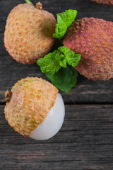 Fresh ripe whole lychee fruits on wooden background
