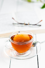 cups of tea with book on wooden table