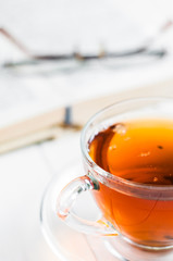 cups of tea with book on wooden table